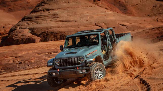 Un Jeep Gladiator gris circulando por la arena