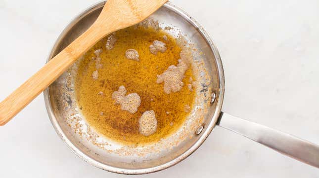 Browned butter in a frying pan with a wooden spoon