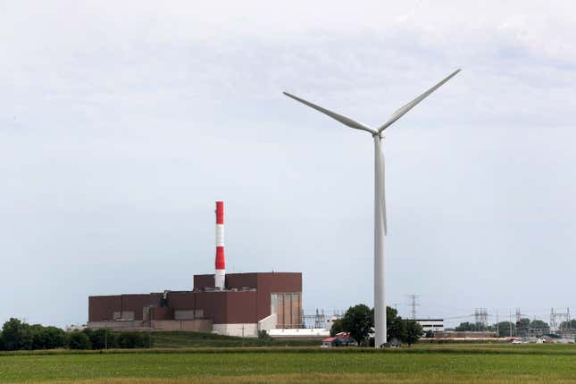 A power generating windmill towers above a power plant