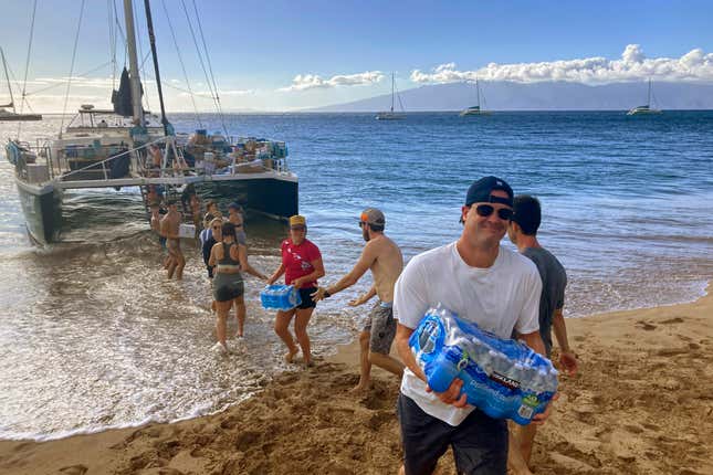 FILE - A group of volunteers who sailed from Maalaea Bay, Maui, form an assembly line on Kaanapali Beach, Saturday Aug. 12, 2023, to unload donations from a boat, after a deadly wildfire destroyed hundreds of homes and left scores of people homeless. It’s a transaction that would be commonplace for a corporation or a sports team, but it’s the kind of deal that is practically unheard of in the nonprofit sector. The philanthropy research organization Candid will send control of its CF Insights website and the staff that gathered information about community foundations to the Council on Foundations, the association of nearly 900 nonprofit members. (AP Photo/Rick Bowmer, File)