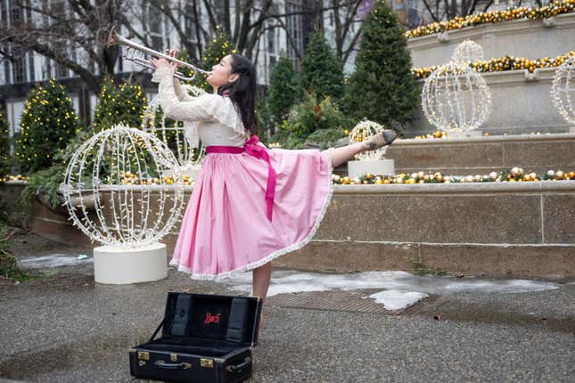 Dancer and musician Seira Soraya plays the trumpet while dancing to The Nutcracker at Grand Army Plaza at 59th Street near the Plaza Hotel on December 24, 2020 in New York City.