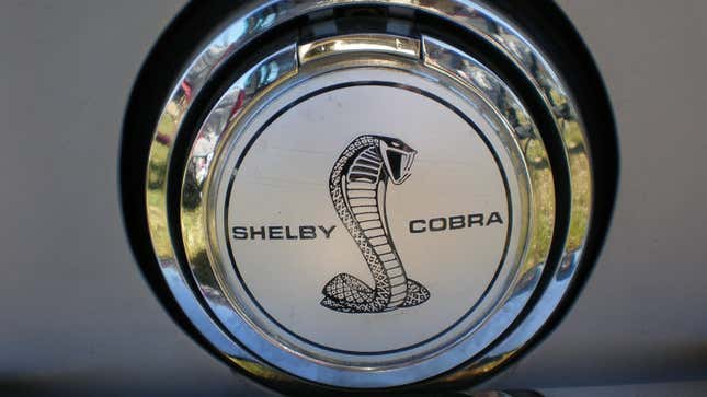 Una foto de una insignia de Shelby Cobra en una tapa de gasolina