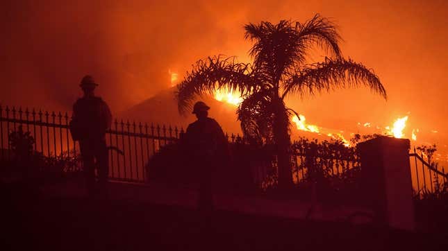 Firefighters work to put out a structure burning during a wildfire Wednesday, May 11, 2022, in Laguna Niguel, Calif. 