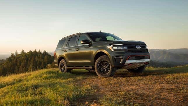 A dark Ford Expedition on a grassy hill.