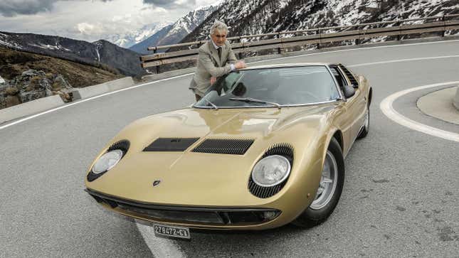 Marcello Gandini posing with a gold Lamborghini Miura