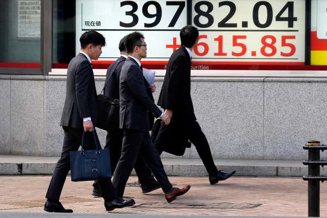 People walk in front of an electronic stock board showing Japan&#39;s Nikkei 225 index at a securities firm Friday, March 1, 2024, in Tokyo. Asian stocks gained Friday, after U.S. stocks climbed to all-time highs Thursday. (AP Photo/Eugene Hoshiko)