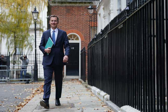 Britain&#39;s Chancellor of the Exchequer Jeremy Hunt walks to his car holding the Autumn Statement booklet outside No 11 Downing Street, in London, Wednesday, Nov. 22, 2023. Hunt will deliver the Autumn Statement to the House of Commons later. (Stefan Rousseau/Pool Photo via AP)