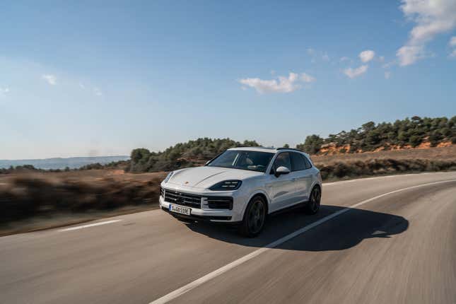 A white 2024 Cayenne S E-Hybrid drives on a Spanish mountain road