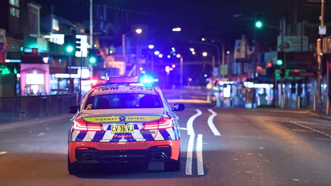 A photo of a Sydney police car driving at night. 