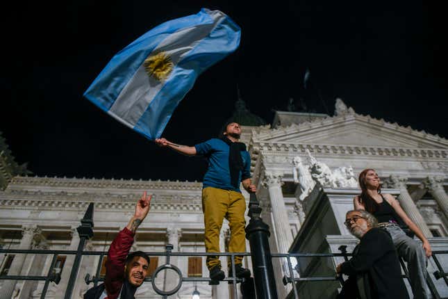 Demonstrators climb to the fence of Congress during protests against economic measures announced by President Javier Milei in Buenos Aires, Argentina, Wednesday, Dec. 20, 2023. Milei announced initiatives to transform the country&#39;s struggling economy, including easing government regulation and allowing privatization of state-run industries as a way to boost exports and investment. (AP Photo/Gustavo Garello)