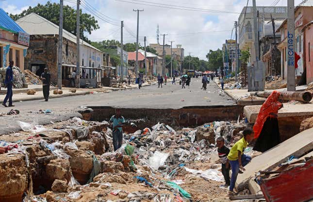 Children play near a road destroyed by rain water that flooded their street in Mogadishu, Somalia May 21, 2018.