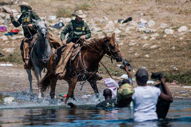 Mounted U.S. Border Patrol agents attempt to contain migrants as they cross the Rio Grande from Ciudad Acuña, Mexico, into Del Rio, Texas, Sept. 19, 2021. 