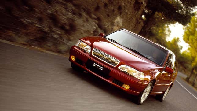 A photo of a red Volvo S70 driving on a road. 