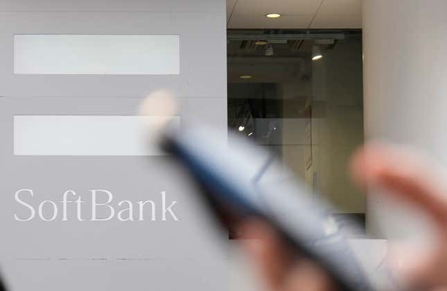 FILE - A pedestrian carries a phone past a SoftBank logo in Tokyo on May 12, 2022. Japanese technology company SoftBank Group Corp. racked up a huge loss in the July-September quarter as some of its investments soured, the company said Thursday, Nov. 9, 2023. (AP Photo/Shuji Kajiyama, File)