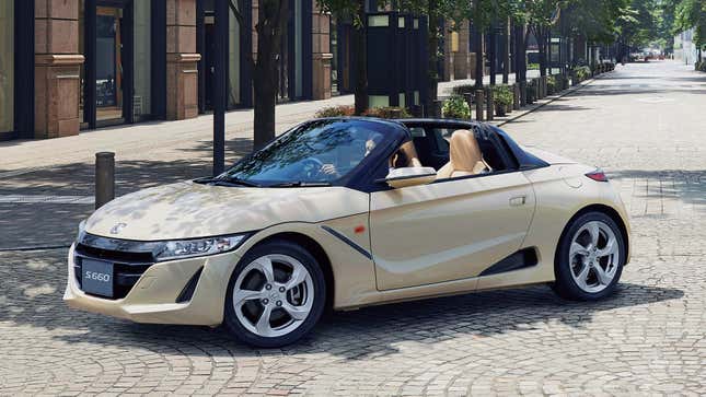 Front-quarter view of a Honda S660 in off-white/cream turning onto a city street