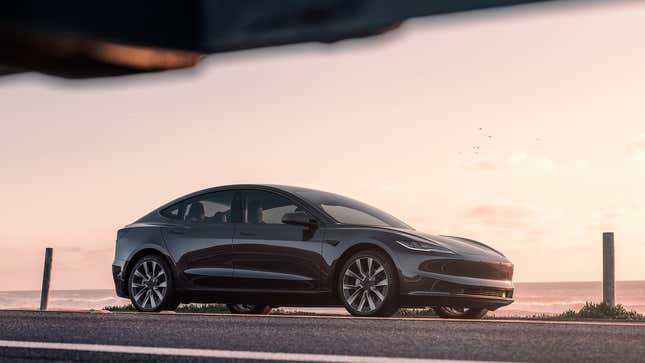 Una foto de un coche eléctrico Tesla Model 3 de gris oscuro. 