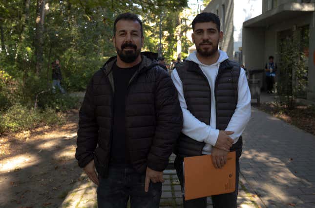 Mirbeycan Gurhan, right, and his uncle Sonar Gurhan pose for a photo after an interview with The Associated Press at the central registration for asylum seekers in Berlin, Germany, Monday, Sept. 25, 2023. Mirbeycan Gurhan, a young Kurdish man said he&#39;d fled suppression by Turkish authorities and paid 6,000 euros, so that smugglers would arrange a flight from Ankara to Belgrade in Serbia, and from there take him by car to Germany. His Uncle applied for asylum four years ago and stood by and translated for him. (AP Photo/Markus Schreiber)