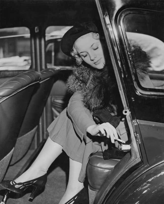 A woman using a car ash tray in the mid-1930s