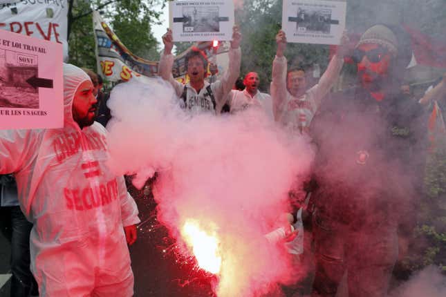 Railway workers burn flares during a demonstration in Paris.