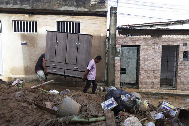 People carry furniture at the scene of a landslide in Recife, Pernambuco State, Brazil. 