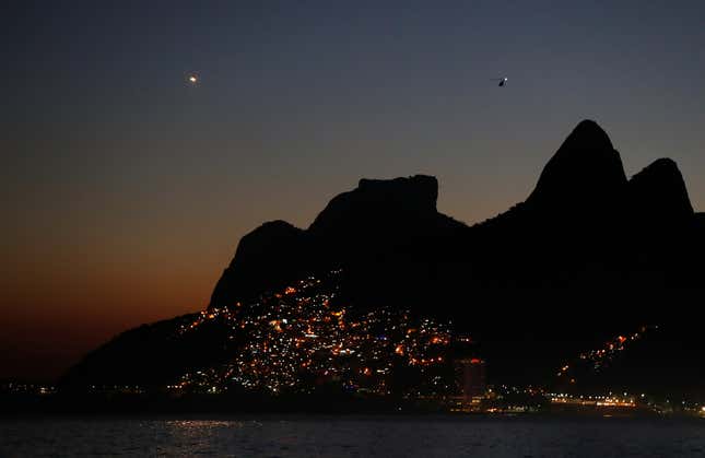 The lights of Vidigal favela are seen with the Dois Irmaos (Two brothers) peaks in Rio de Janeiro, Brazil July 4, 2016. REUTERS/Pawel Kopczynski - RTX2JPHS