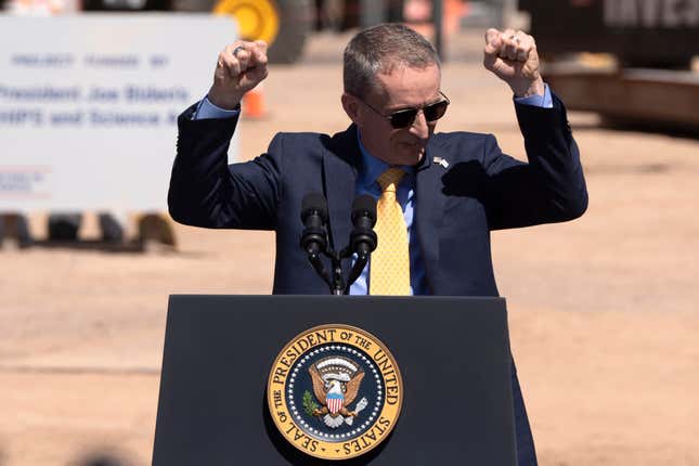 Pat Gelsinger with his arms raised in excitement while standing behind a podium with the presidential seal