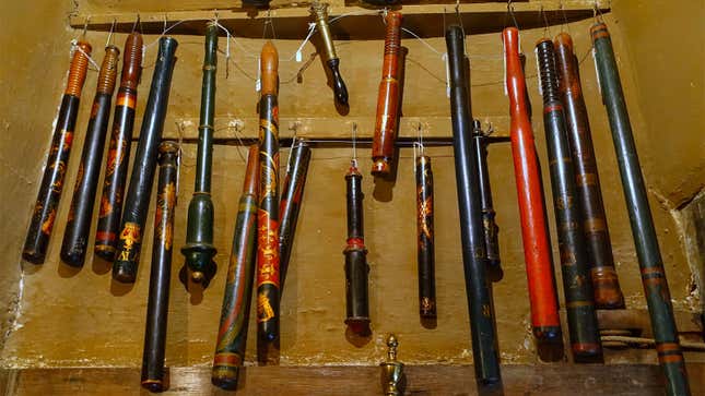 A photo of a collection of vintage truncheons hanging on a wall. 