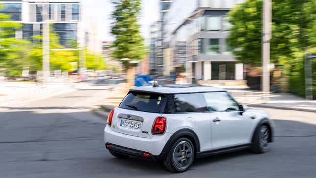 Ein weißer Mini Cooper SE macht eine Kehrtwende in einer Stadt