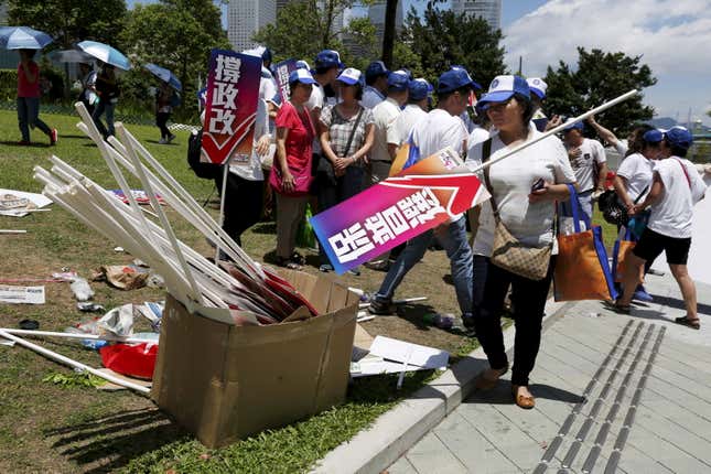A pro-China supporter puts down a placard which reads “support universal suffrage.”