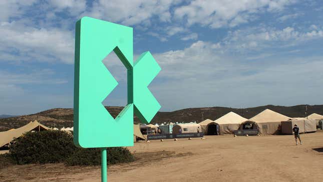 Una foto de un logotipo verde de Extreme E frente al sitio de Cerdeña. 