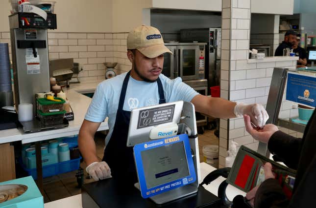 An employee collects payment at an Auntie Anne&#39;s and Cinnabon store in Livermore, Calif., Thursday, March 28, 2024. He&#39;s among hundreds of thousands of California fast-food workers who will be paid at least $20 an hour starting Monday, April 1. (AP Photo/Terry Chea)