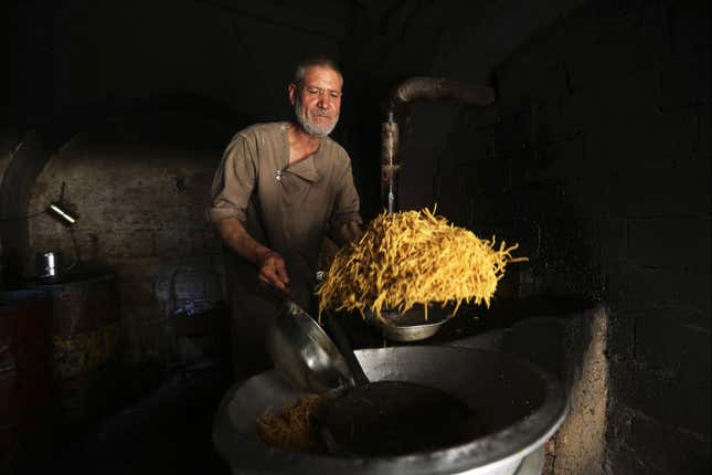 A man in Kabul, Afghanistan, prepares sweets in a small factory.