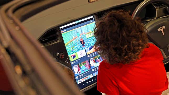 A photo of a child playing games on a car's infotainment system. 