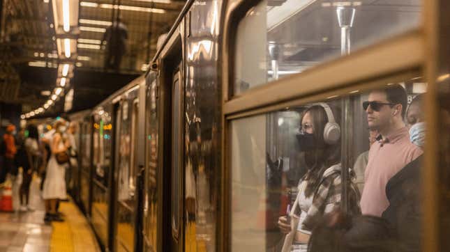 Passengers wait for a subway car to depart a station