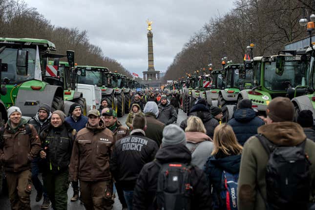 Farmers walk between tractors as they arrive for a protest in Berlin, Germany, Monday, Jan. 15, 2024. Farmers drove thousands of tractors into Berlin on Monday in the climax of a week of demonstrations against a plan to scrap tax breaks on the diesel they use, a protest that has tapped into wider discontent with Germany’s government. (AP Photo/Ebrahim Noroozi)