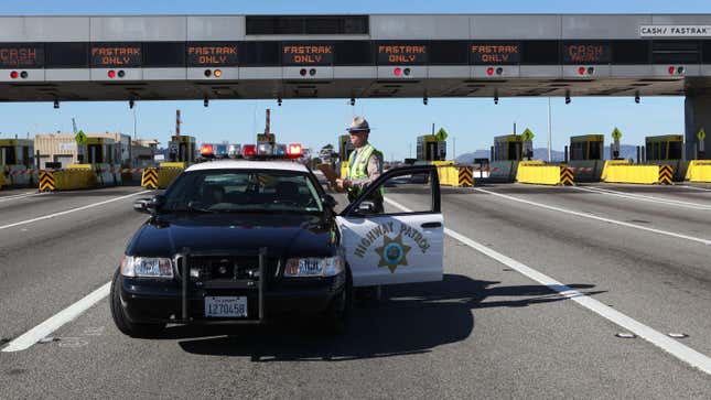 California Highway Patrol officer Rick Baller stands next to his car as he guards the closed toll plaza leading to the San Francisco Bay Bridge October 28, 2009 in Oakland, California.