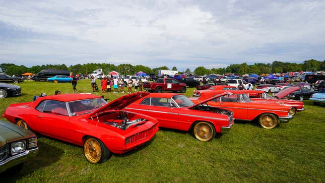 Ein Foto von drei roten Autos mit geöffneten Motorhauben. 