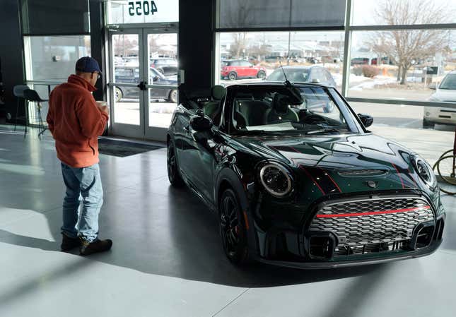 FILE - A man looks at a 2024 Cooper S John Cooper Works convertible at a Mini dealership on Nov. 30, 2023, in Loveland, Colo. Automobile prices, which had been fueling inflation in the U.S., are starting to drop, helping to slow overall consumer price increases and giving buyers hope of getting a deal. (AP Photo/David Zalubowski, File)