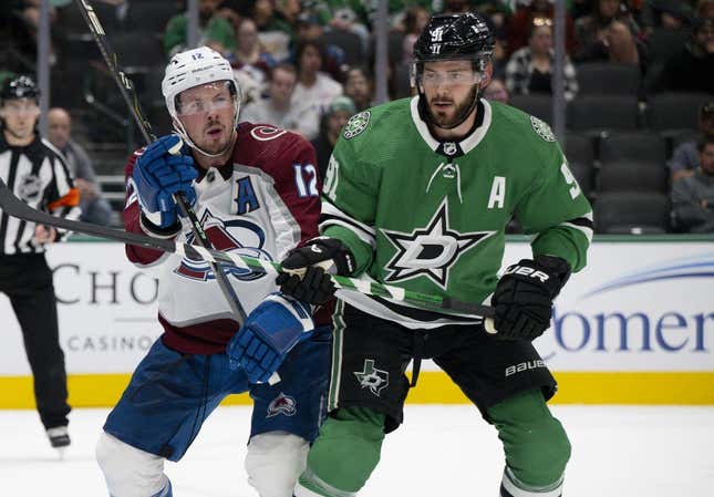 Oct 3, 2023; Dallas, Texas, USA; Colorado Avalanche center Ryan Johansen (12) and Dallas Stars center Tyler Seguin (91) battle for position in the Stars zone during the first period at the American Airlines Center.