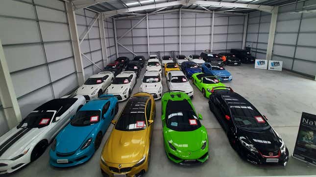 A photo of a warehouse full of 25 stolen cars. 