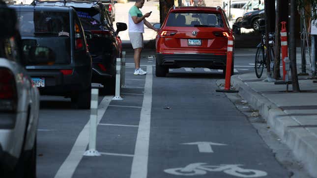 A motorist enters his vehicle parked in a bicycle lane in the 500 block of West Kinzie Street, June 29, 2022, in Chicago