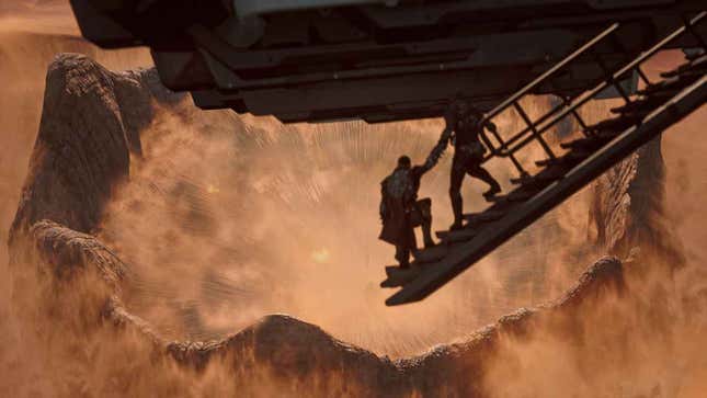 Two figures in a helicopter look as a giant sand worm arises out of the desert