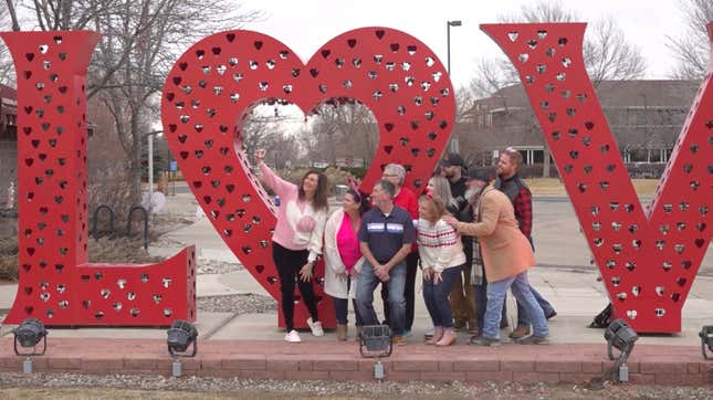 Volunteers pose for a photo in front of a “Love” art installation at the visitors center in Loveland, Colo., on Wednesday, Feb. 7, 2024. Every year, tens of thousands of people from around the world route their Valentine’s Day cards to the “Sweetheart City” to get a special inscription and the coveted Loveland postmark. The re-mailing tradition has been going on for nearly 80 years and is the largest of its kind in the world. (AP Photo/Thomas Peipert)