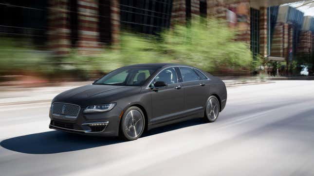 Une Lincoln MKZ grise circulant devant des bâtiments