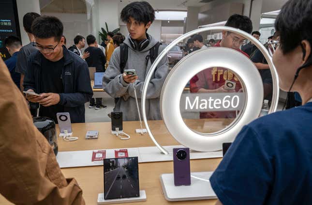 People look at newly launched Mate60 smartphones at a Huawei flagship store