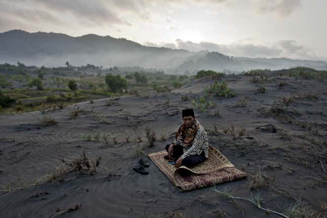 A muslim man sits on ‘sea of sands’ as he waits for Eid Al-Fitr prayer at Parangkusumo Beach, Indonesia.