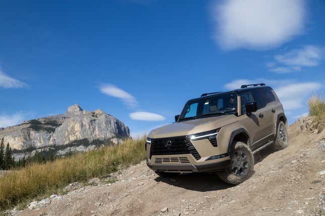 Front 3/4 view of a beige Lexus GX 550 driving down a hill