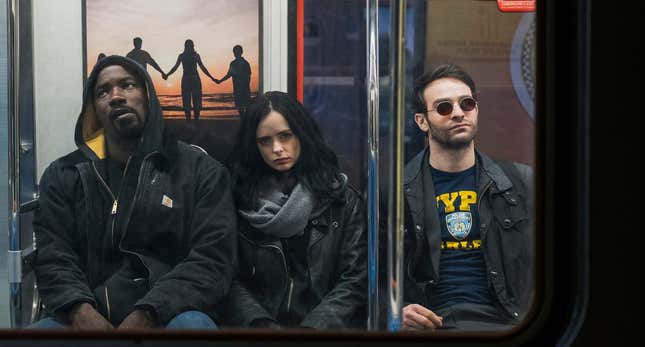 A haggard Luke Cage, Jessica Jones, and Matt Murdock sit on a New York subway in a scene from The Defenders.