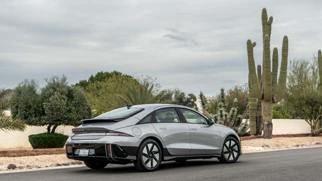 The back of a gray IONIQ 6 parked on the street in front of a cactus in the desert