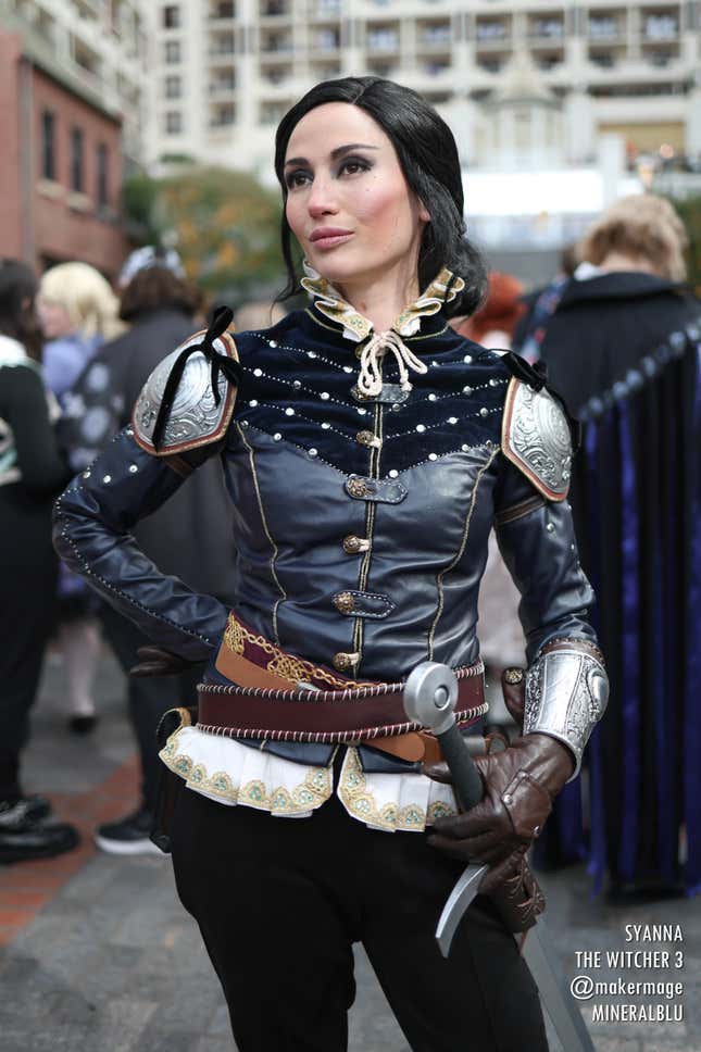 A Syanna cosplayer looks off-camera, hand on their sword hilt. 